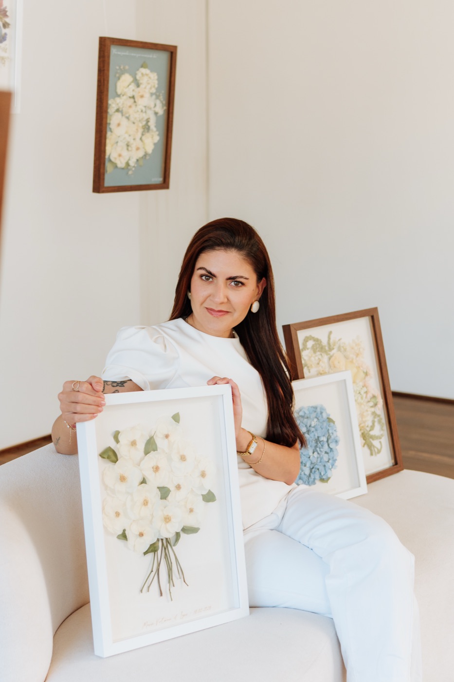 Magda Renata no ateliê, com quadros afetivos